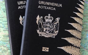 New Zealand passport sits on top of world map.