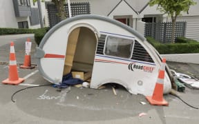 Multiple parked vehicles were damaged by a driver in a stolen vehicle towing a caravan that was fleeing police.
