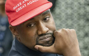 Kanye West listens as he as he and Jim Brown meet with United States President Donald J. Trump in the Oval Office of the White House in Washington, DC on Thursday, October 11