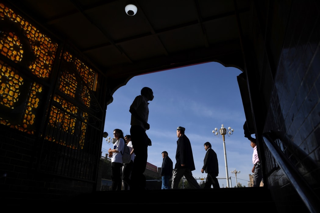 This photo taken on June 5, 2019 shows Uighur men walking past the exit of an underpass after attending Eid al-Fitr prayers, marking the end of Ramadan, in Kashgar in China's northwest Xinjiang region.
