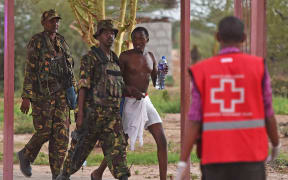 A male student hostage is escorted out of Garissa University.
