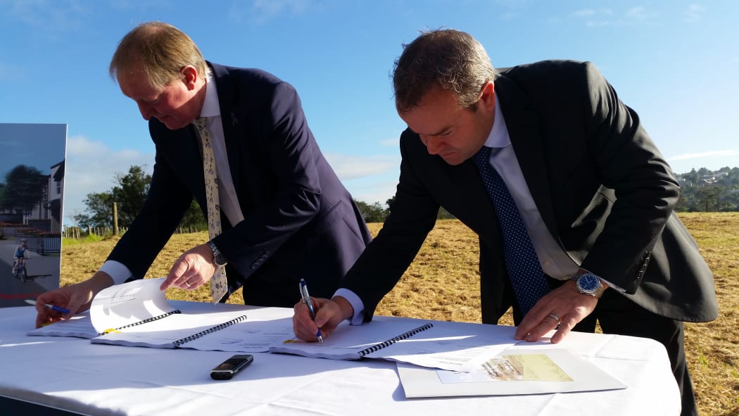 Housing Minister Nick Smith and Fletcher Building CEO Steven Evans sign the contract to build 196 homes on Moire Rd.