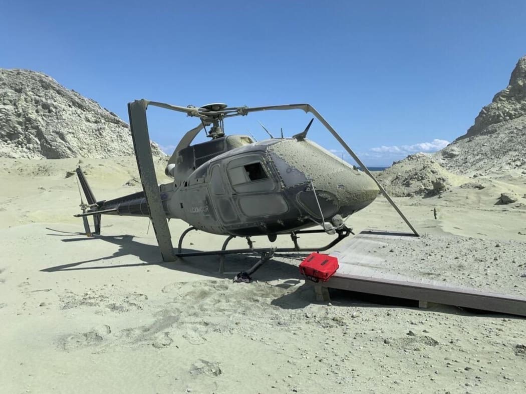 A damaged helicopter is seen on White Island after the eruption.