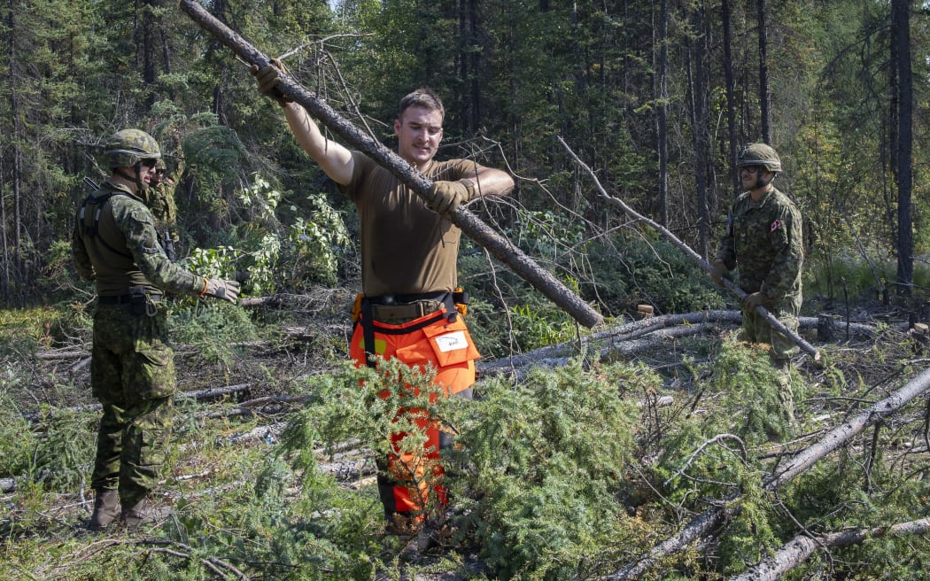 Members of the Canadian Armed Forces constructing a firebreak in Yellowknife, Northwest Territories, Canada. The government of Canada's Northwest Territories declared a state of emergency on Tuesday and issued the evacuation order on Wednesday in response to out-of-control wildfires. Mass evacuation of areas in the territory is ongoing, including the capital city of Yellowknife, the territory's largest community with a population of more than 20,000. Residents were ordered to leave by noon Friday.
