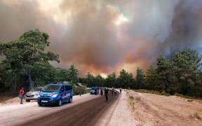 Flames and a massive cloud of smoke cover a fire-hit area in Manavgat, Antalya, southern Turkey, July 28, 2021. At least three people were killed, 100 injured and several have been evacuate in the massive wildfires of the resort city.