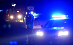 Police block the road near the village of Malo Orasje, just outside the town of Mladenovac, about 60 kilometres (37 miles) south of Serbia's capital Belgrade, on May 05, 2023. - Eight people were killed and 13 injured late May 4, 2023 in a shooting near Mladenovac, as the attacker opened fire with an automatic weapon from a moving vehicle and fled, state-run media reported. (Photo by Andrej ISAKOVIC / AFP)