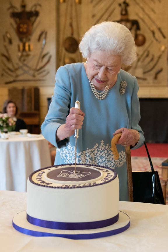 Queen Elizabeth II cuts a cake to celebrate the start of the Platinum Jubilee during a reception in the Ballroom of Sandringham House, the Queen's Norfolk residence.