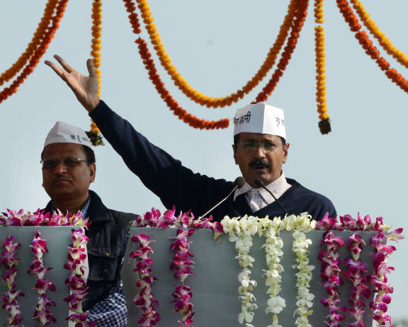 Chief Minister Arvind Kejriwal gestures as he addresses supporters after taking the oath of office in Delhi.
