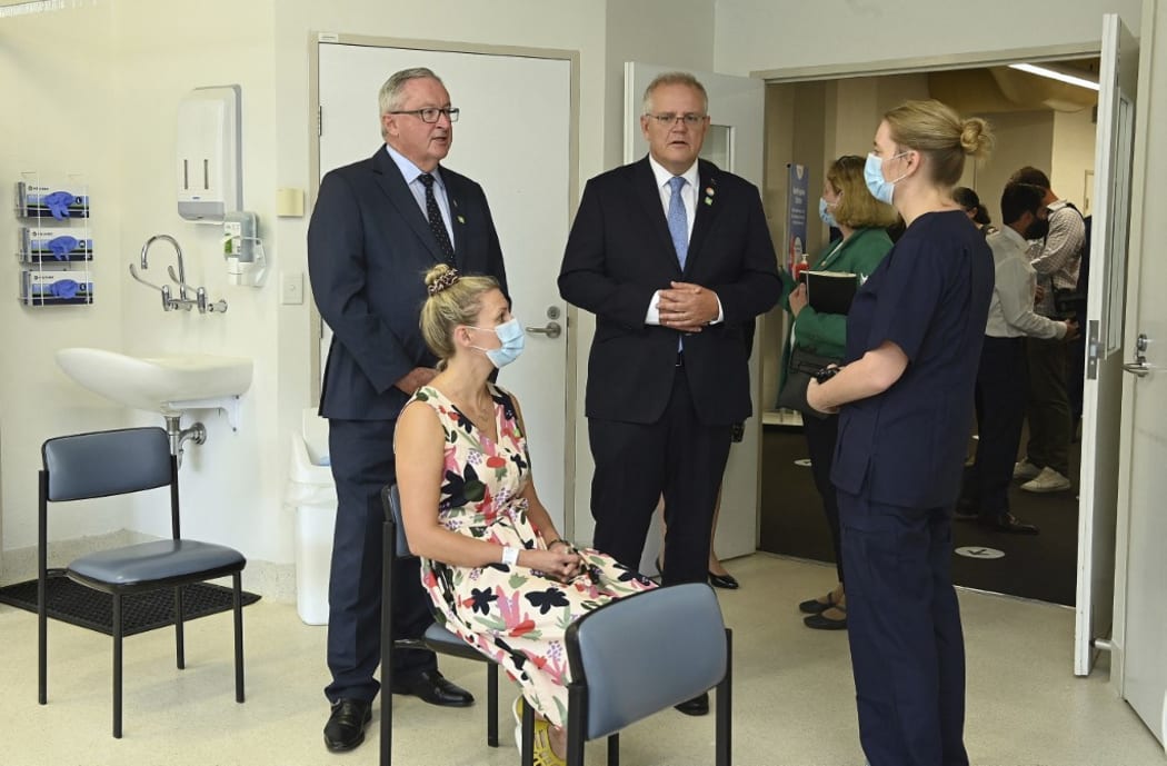 Australian Prime Minister Scott Morrison (C) and New South Wales health minister Brad Hazzard (L) tf the COVID-19 vaccine process in Sydney on February 19, 2021.