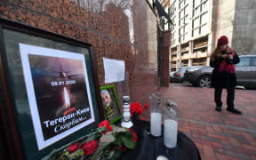 Flowers, candles and a placard reading "Tehran-Kiev We mourn" outside the Iranian embassy in Kiev on 8 January, in remembrance of the victims of the Ukraine International crash in Tehran.