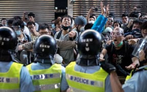 People jeer and yell at police officers in the Mongkok district of Hong Kong on 17 October 2014.