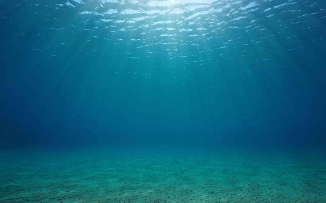 Underwater seascape sandy seabed with natural sunlight below water surface in the Mediterranean sea, France