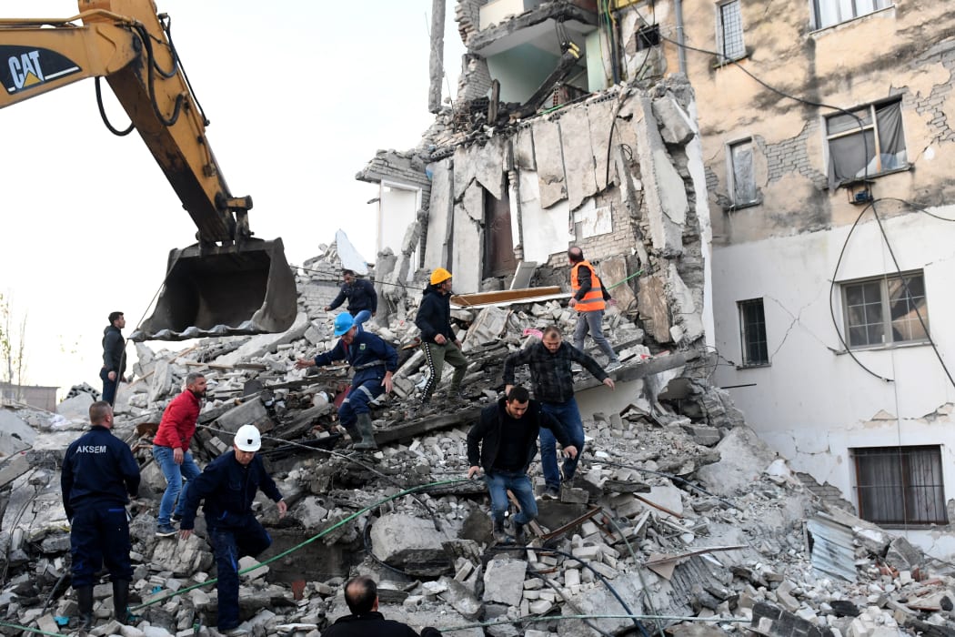 Emergency workers clear debris at a damaged building in Thumana after an earthquake hit Albania, on 26 November, 2019.