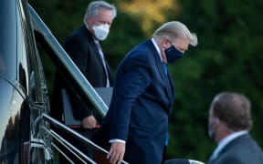 White House Chief of Staff Mark Meadows (L) watches as US President Donald Trump (C) walks off Marine One while arriving at Walter Reed Medical Center in Bethesda, Maryland on October 2, 2020.