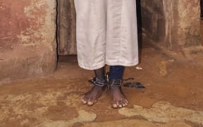 EDITORS NOTE: Graphic content / A man stands with chains on his ankles and wrists on September 26, 2019 in the Rigasa area of Kaduna in northern Nigeria where 300 male students of "different nationalities" were rescued by police from an Islamic seminary where they were tortured and sodomised. -
