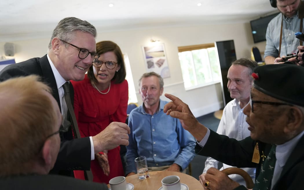 FILE - Britain's Labour Party leader Keir Starmer, left, with Labour candidate Alex Baker, 2nd left, visits a veterans coffee morning at Aldershot Town Football Club in Aldershot, England, Saturday June 29, 2024, to mark Armed Forces Day, while on the General Election campaign trail. (Stefan Rousseau/PA via AP, File)