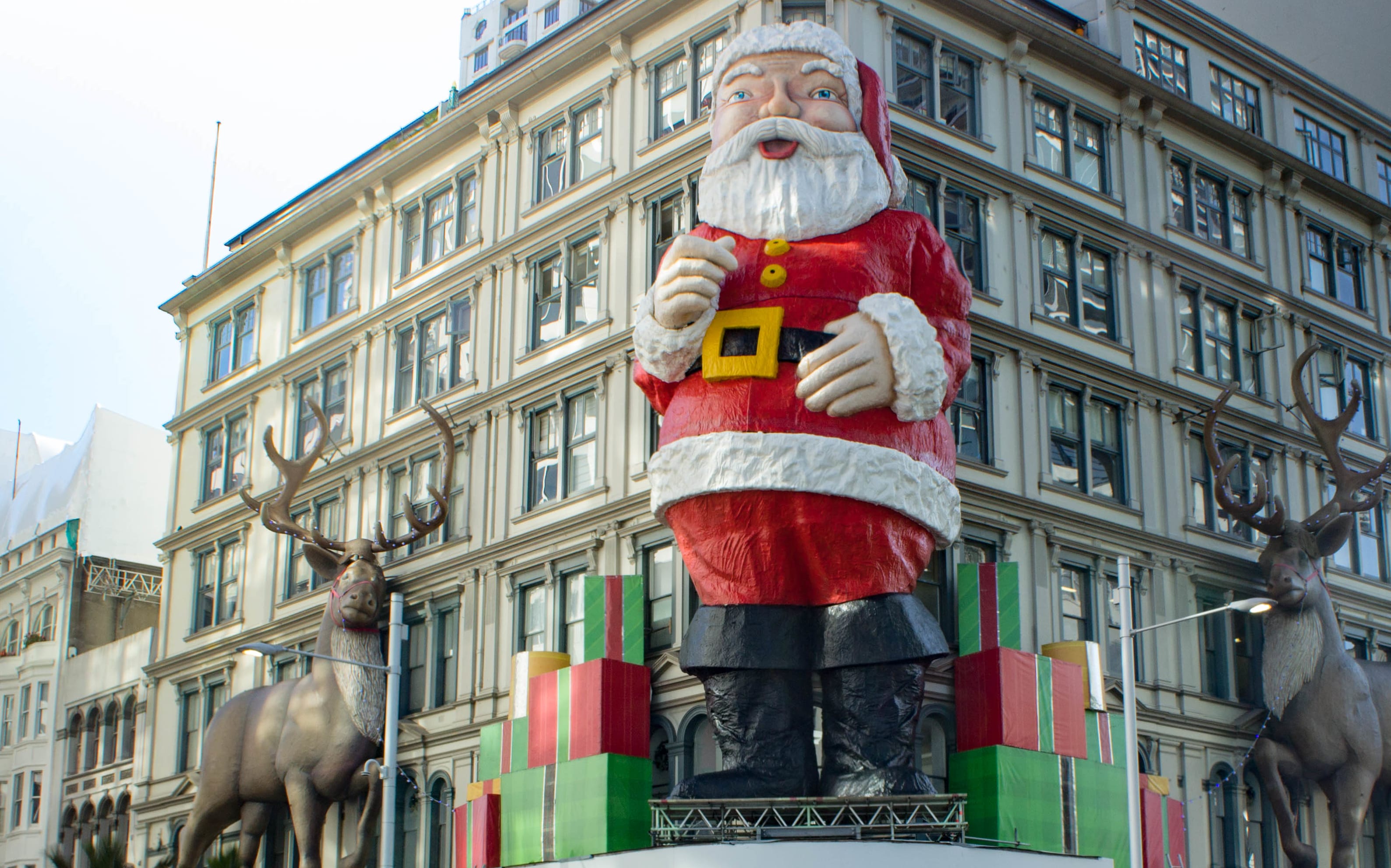 A giant Santa on Queen Street overlooks shoppers crossing the road in the Auckland Central City.