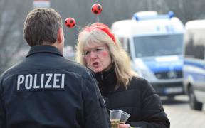 A Police officer speaks with a carnival reveler in Braunschweig.