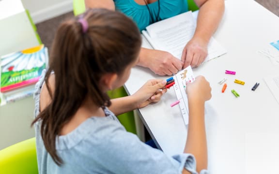 Teacher working with a teenage girl with learning difficulties.
