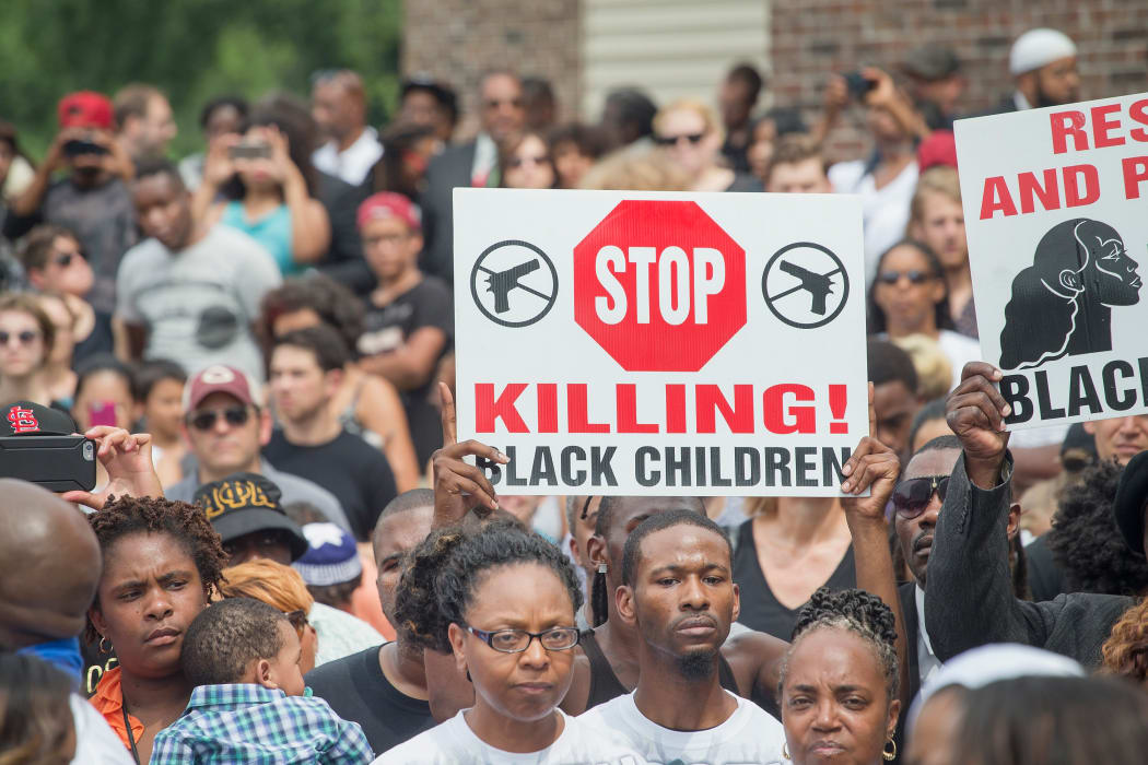 Several hundred people paused in silence in the US town of Ferguson to mark the first anniversary of Michael Brown's  shooting.