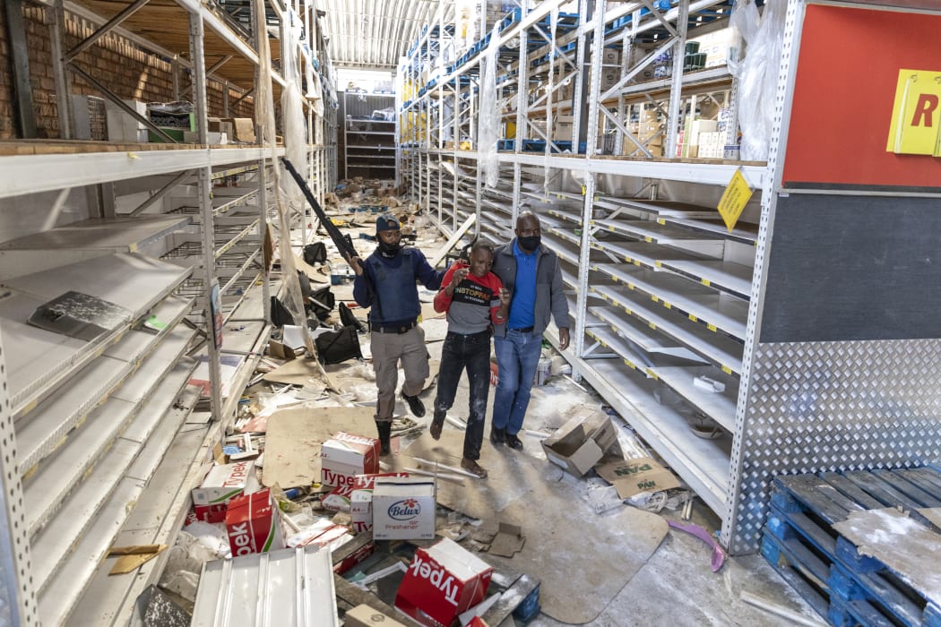 South African Police Services (SAPS) members arrest a looter at the Gold Spot Shopping Centre in Vosloorus, southeast of Johannesburg, on July 12, 2021.
