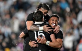 Beauden Barrett of New Zealand celebrates his try with TJ Perenara and Caleb Clarke.