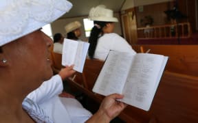 A lady singing from a hymnal at the Samoan Methodist Church in Levin.