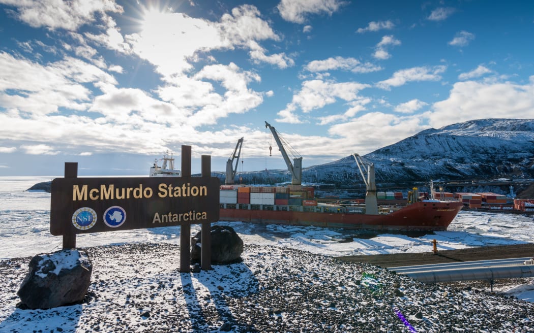 Jan 02, 2019: McMurdo Station Antarctica sign with cargo ship unloading