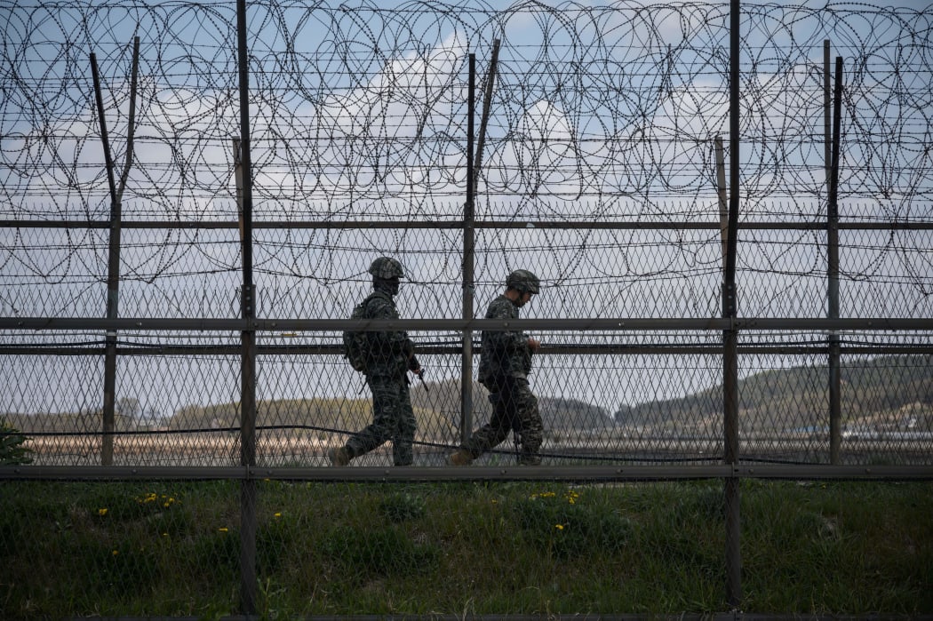 South Korean soldiers patrol along a barbed wire fence Demilitarized Zone (DMZ) separating North and South Korea, on the South Korean island of Ganghwa on April 23, 2020.