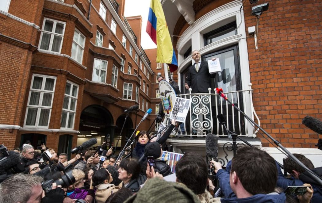Julian Assange (centre) addresses media and supporters from the balcony of Ecuador's embassy.