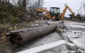 Crews work to clear roadways of debris caused by one of several tornadoes that tore through the state overnight.