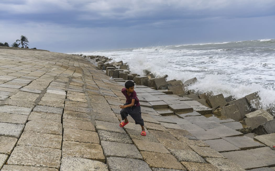 A boy tries to escape from a wave at Shahpori island in Teknaf ahead of Cyclone Mocha's landfall in Cox's Bazar, Bangladesh on May 13, 2023. Bangladesh has raised the cyclone warning signal to 10 for Cox's Bazar and Teknaf areas.