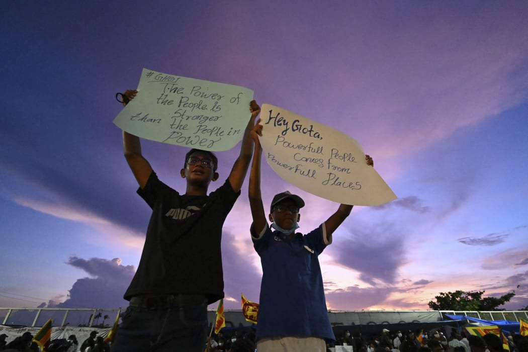 Protesters hold placards as they participate in an anti-government demonstration near the president's office in Colombo on April 17, 2022, d (Photo by Ishara S. KODIKARA / AFP)