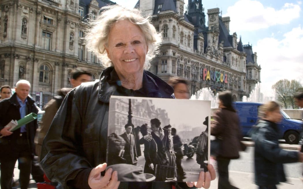 Françoise Bornet, héroïne du "Baiser de l'Hôtel de Ville" (1950) du photographe Robert Doisneau, est photographiée le 20 avril 2005 près de l'Hôtel de ville à Paris, avec une copie de la photo. Propriétaire du tirage original, elle le mettra aux enchères le 25 avril à l'Hôtel Dassault à Paris le 25 avril prochain. Il est estimé entre 15.000 et 20.000 EUR.
 AFP PHOTO ERIC FEFERBERG

Francoise Bornet, the woman in Robert Doisneau's famous photography "Baiser de l'Hotel de Ville" (1950), poses 20 April 2005 in Paris with a print of the picture. Bornet, who owns the original print, will sell it at the Hotel Dassault auction house in Paris 25 April 2005. The print is estimated to fetch between 15,000 and 20,000 euros. AFP PHOTO ERIC FEFERBERG (Photo by ERIC FEFERBERG / AFP)