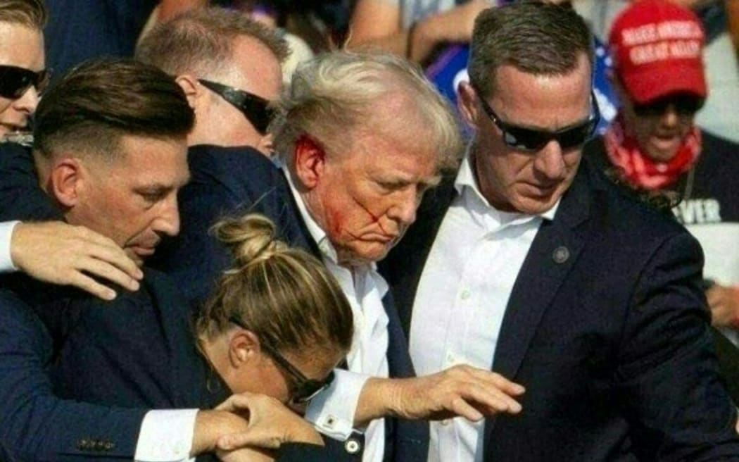 Republican candidate Donald Trump is seen with blood on his face surrounded by secret service agents as he is taken off the stage at a campaign event at Butler Farm Show Inc. in Butler, Pennsylvania, July 13, 2024. Republican candidate Donald Trump was evacuated from the stage at today's rally after what sounded like shots rang out at the event in Pennsylvania, according to AFP.
The former US president was seen with blood on his right ear as he was surrounded by security agents, who hustled him off the stage as he pumped his first to the crowd.
Trump was bundled into an SUV and driven away. (Photo by Rebecca DROKE / AFP)