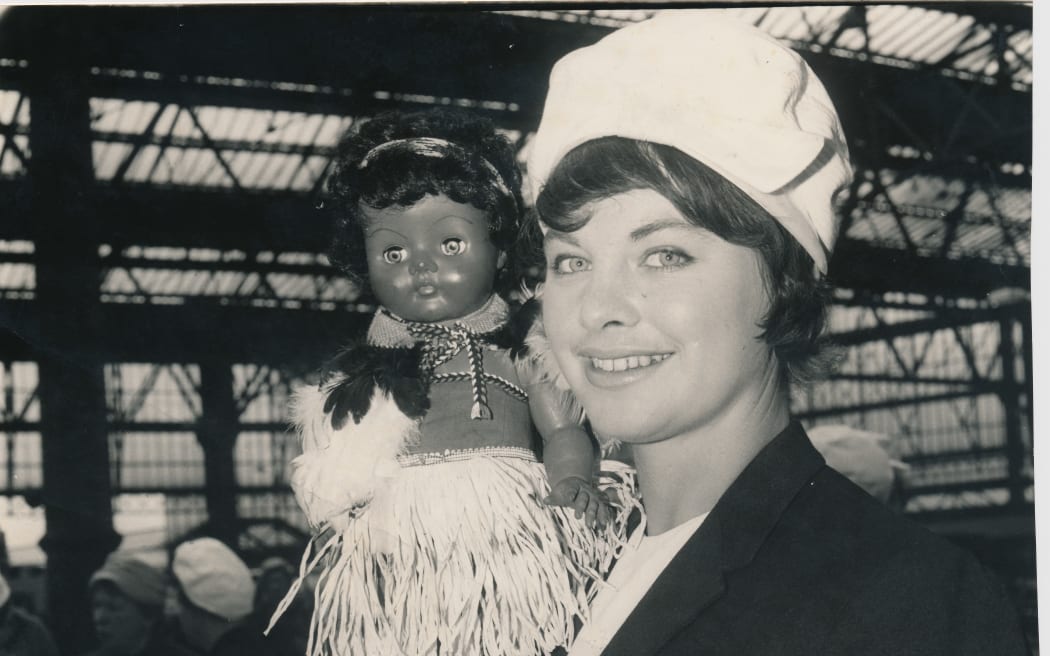 Joan Harnett on tour for the Silver Ferns, holding the team's mascot.