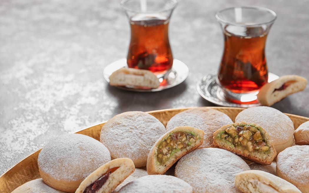 Traditional cookies for Islamic holidays such as Eid, and tea on a table.