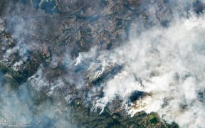 This handout satellite image courtesy of NASA Earth Observatory taken on August 16, 2023 shows wildfires burning northeast of Yellowknife, Northwest Territories, Canada. Thousands ordered to flee wildfires advancing on one of the largest cities in Canada's far north started leaving on emergency evacuation flights August 17, 2023, as convoys snaked south to safety on the only open highway. The order late August 16 to evacuate Yellowknife in the Northwest Territories marked the latest chapter of a terrible summer for wildfires in Canada, with tens of thousands of people forced to leave their homes and vast swaths of land scorched. (Photo by NASA Earth Observatory / AFP) / RESTRICTED TO EDITORIAL USE - MANDATORY CREDIT "AFP PHOTO / NASA Earth Observatory)" - NO MARKETING NO ADVERTISING CAMPAIGNS - DISTRIBUTED AS A SERVICE TO CLIENTS