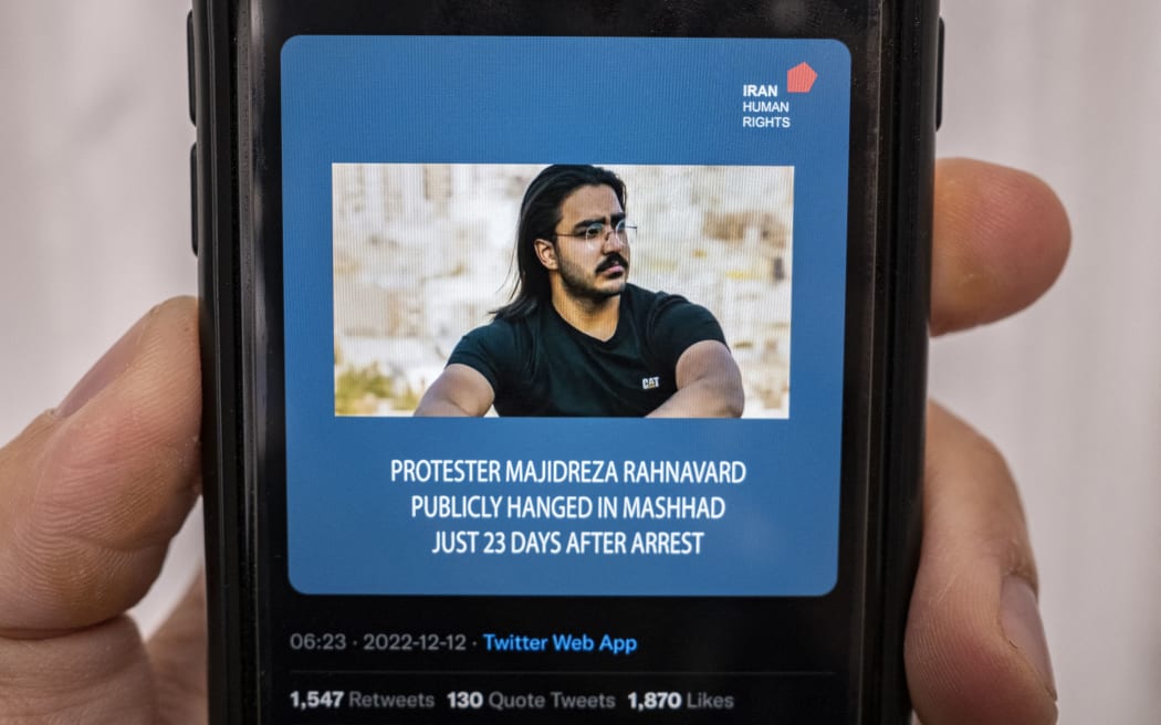 A mobile phone displays a Tweet about the execution announced by Iranian authorities of Majidreza Rahnavard, the second capital punishment linked to nearly three months of protests, 12 December 2022.