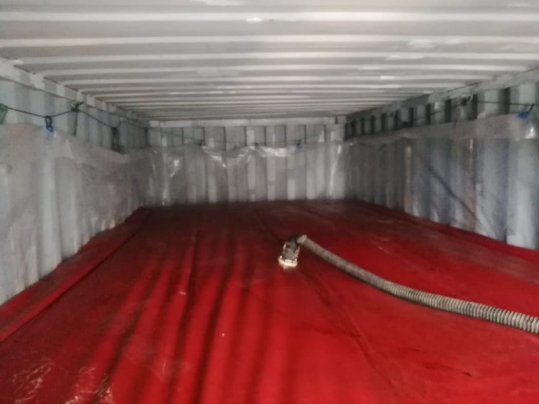 A large 'flexitank' bag inside a shipping container.