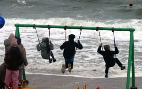 ODESA, UKRAINE - NOVEMBER 6, 2022 - Children are seen on the swings as a storm hits the Black Sea coast of Odesa, southern Ukraine.NO USE RUSSIA. NO USE BELARUS. (Photo by Yulii Zozulia / NurPhoto / NurPhoto via AFP)