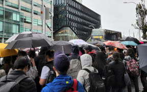 Students waiting for a bus outside AUT on 9 May, 2023.