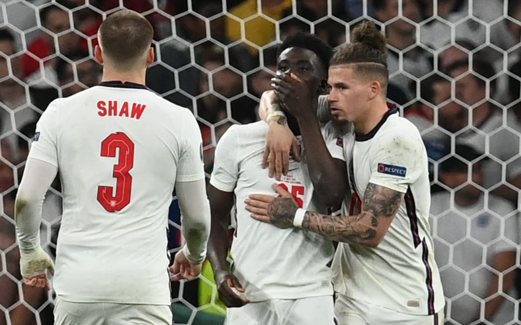 England's midfielder Bukayo Saka (C) reacts after failing to score in the penalty shootout during the UEFA EURO 2020 final football match between Italy and England at the Wembley Stadium in London on 11 July 2021.