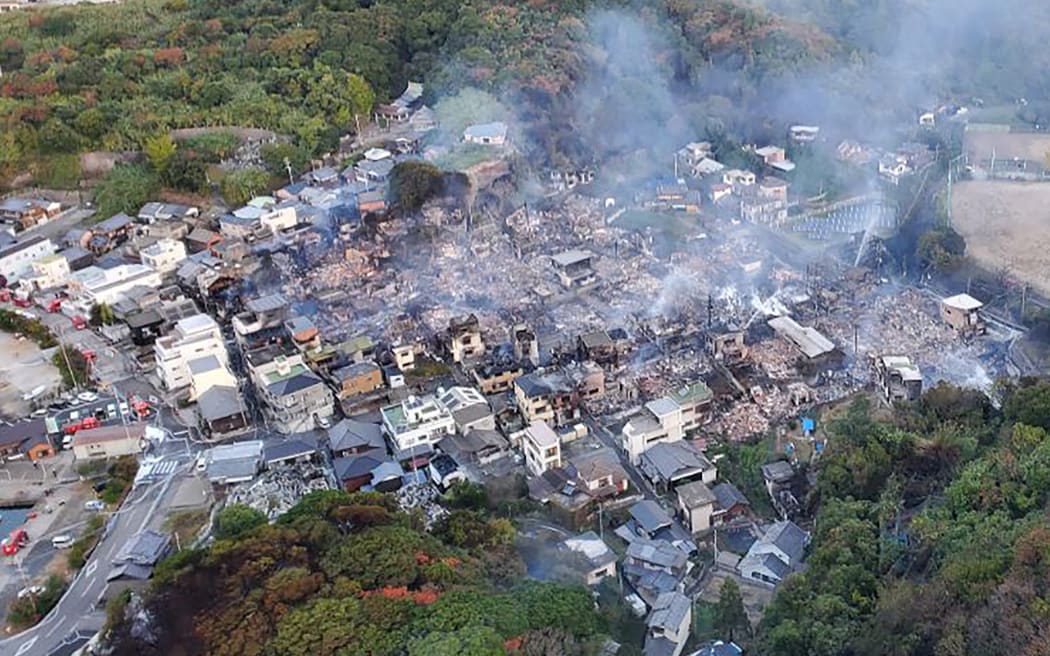 An aerial view of the scene following an overnight fire in a residential area near the Saganoseki Fishing Port in Oita City.