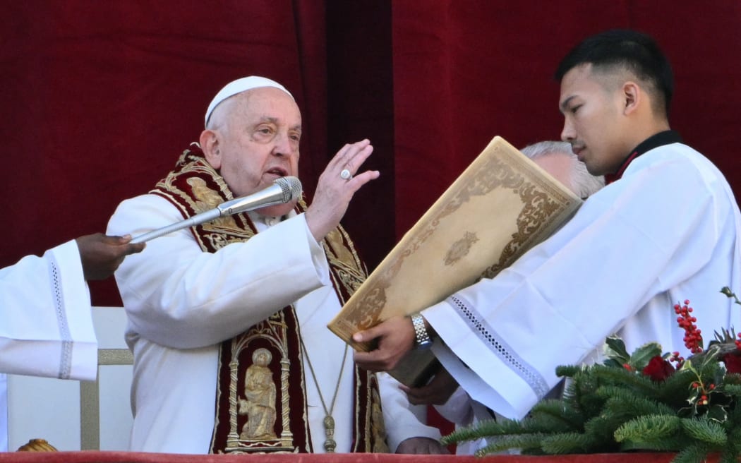 Pope Francis delivers the Urbi et Orbi message and blessing to the city and the world from  the main balcony of St. Peter's basilica as part of Christmas celebrations, at St Peter's square in the Vatican on December 25, 2024. (Photo by Alberto PIZZOLI / AFP)