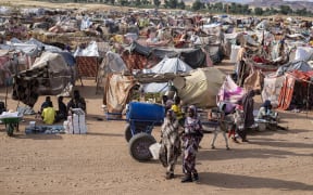Displaced Sudanese who fled El-Fasher after the city fell to the Rapid Support Forces (RSF), walk in the Um Yanqur camp, located on the southwestern edge of Tawila, in war-torn Sudan's western Darfur region on November 3, 2025. (Photo by AFP)