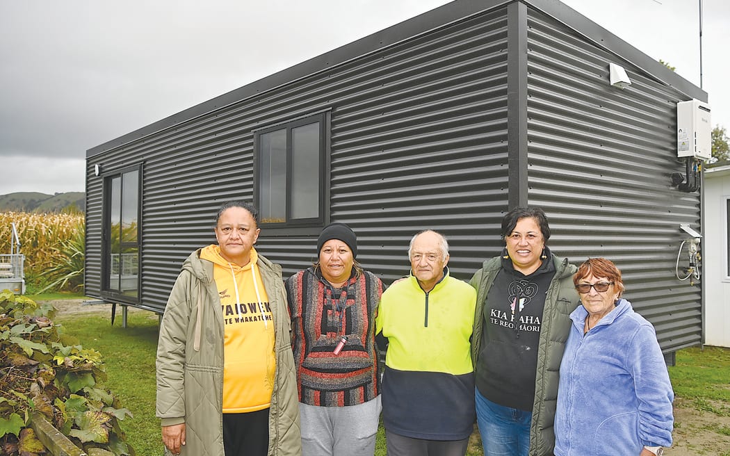 Fifteen relocatable homes are being delivered to Tairāwhiti this month, for those affected by Cyclone Gabrielle. Claude Ruru (centre) stands in front of his new transportable pod with (from left) Te Karaka Community Lead Pimia Wehi, Alicia Ruru, chief executive Robyn Rauna and Mihi Ruru.
