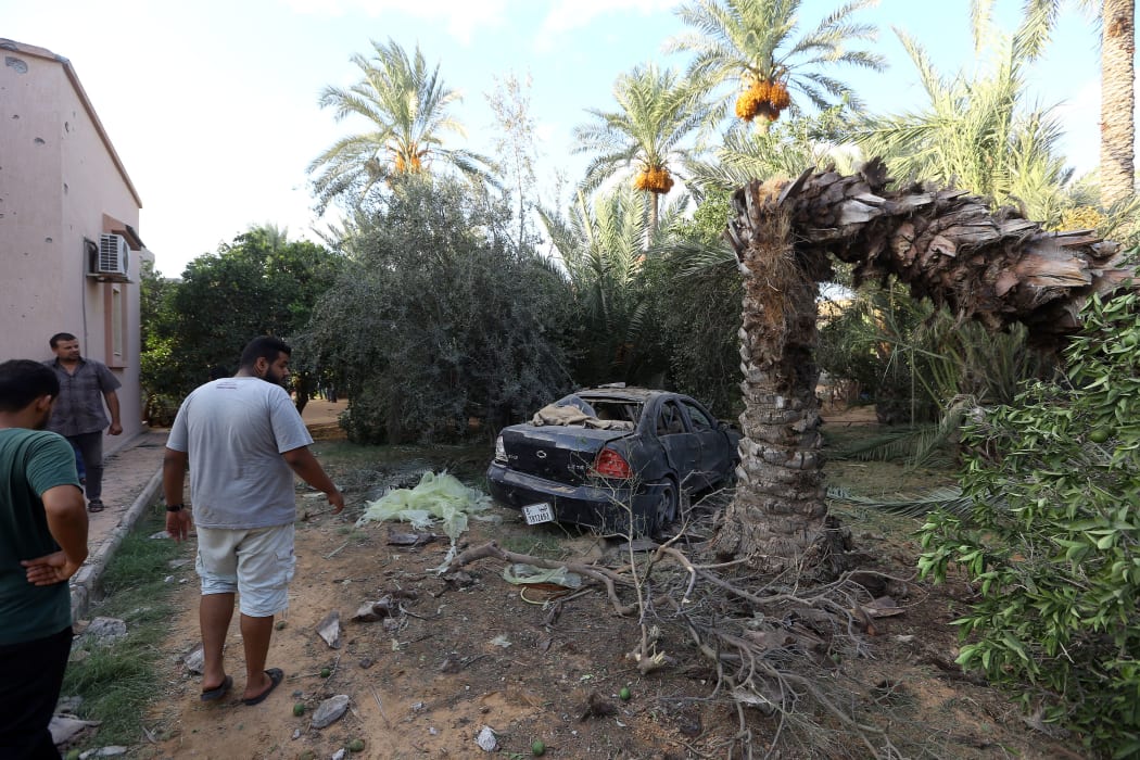 Libyans gather at the site of where a mortar shell landed in the capital Tripoli on August 30, 2018.