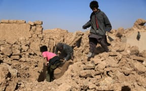 Afghan residents clear the debris of houses that were damaged in a series of earthquakes, in Injil district of Herat province on October 15, 2023. A magnitude 6.3 earthquake killed two people in western Afghanistan on October 15, with damaged prisons emptied and residents fleeing a region where tremors have claimed at least 1,000 lives this past week. (Photo by Mohsen KARIMI / AFP)