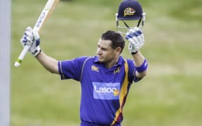 Nathan McCullum lifts his bat after scoring a century in the domestic one-day competition.